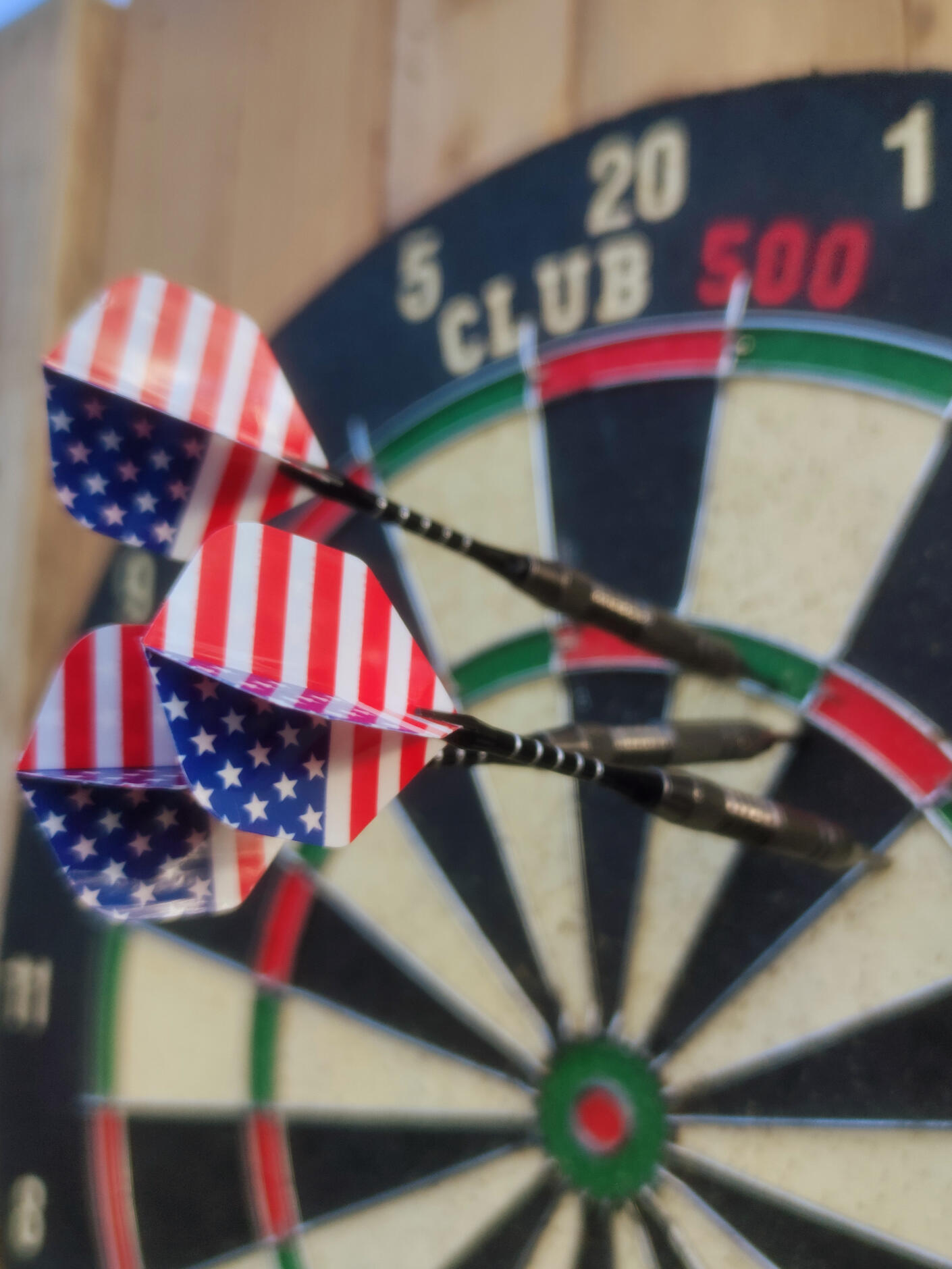 Piko Event | Photo du jeu cible de fléchettes, zoomée sur trois fléchettes avec drapeau américain plantées dans la cible. Jeu sur support en bois. Lien vers les règles du jeu