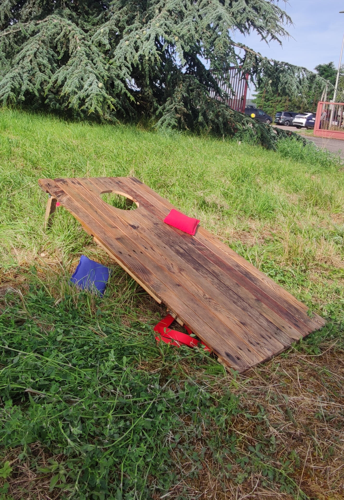 Piko Event | Photo du jeu cornhole. Jeu en bois dans l'herbe, après-midi entre collègues. Lien vers les règles du jeu