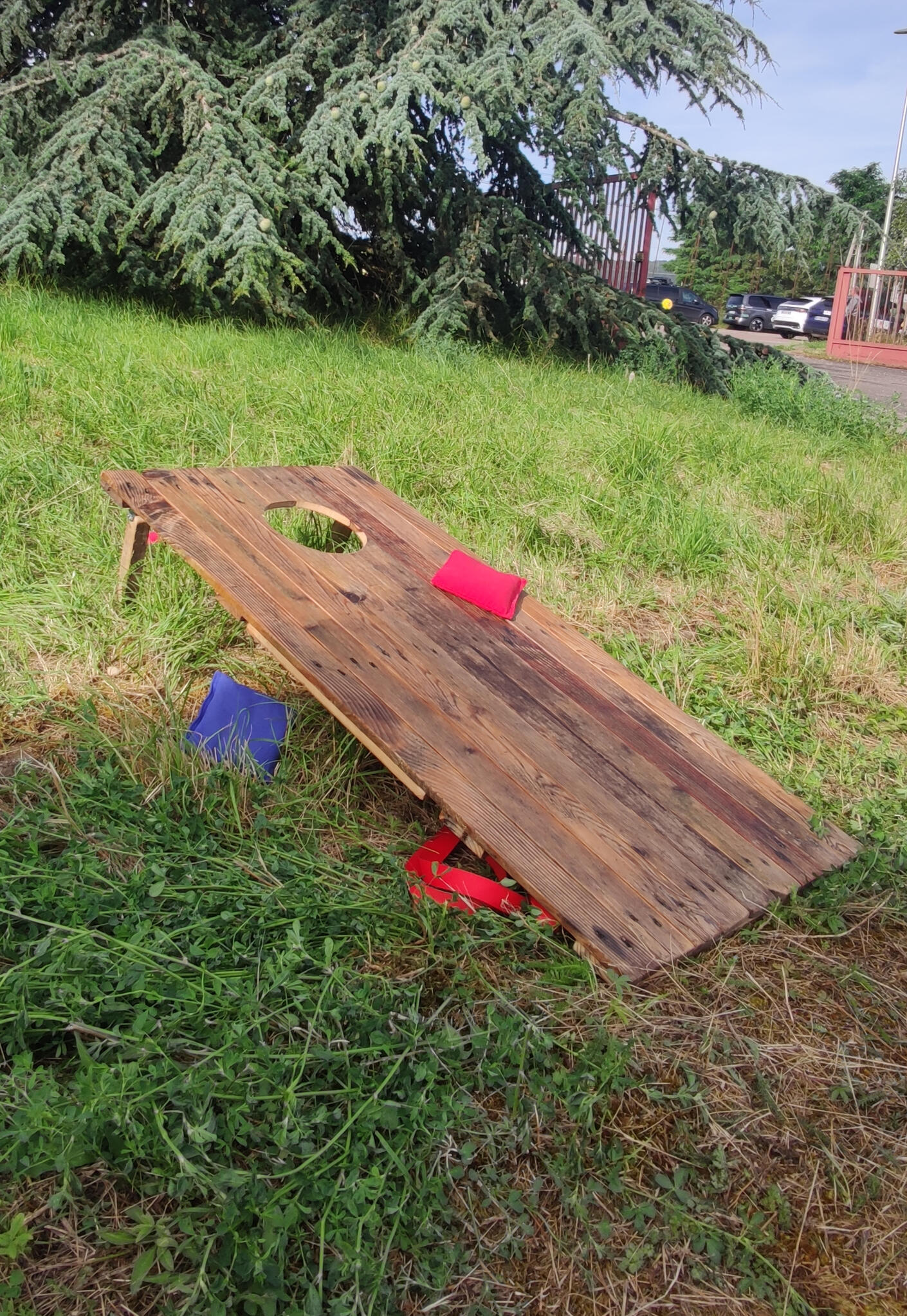 Piko Event | Photo du jeu cornhole. Jeu en bois dans l'herbe, après-midi entre collègues. Lien vers les règles du jeu